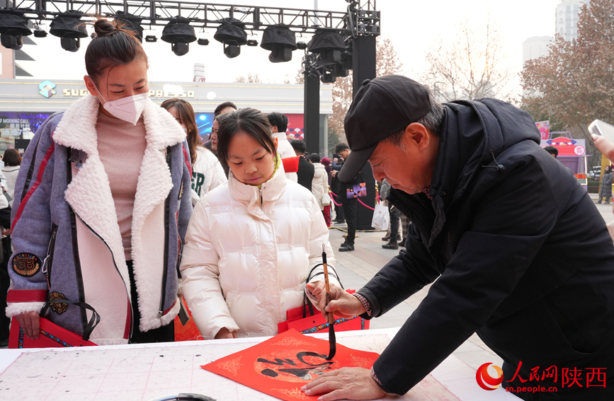 年貨節(jié)現(xiàn)場送春聯(lián)活動(dòng)吸引市民圍觀。人民網(wǎng)記者 賈凱璐攝
