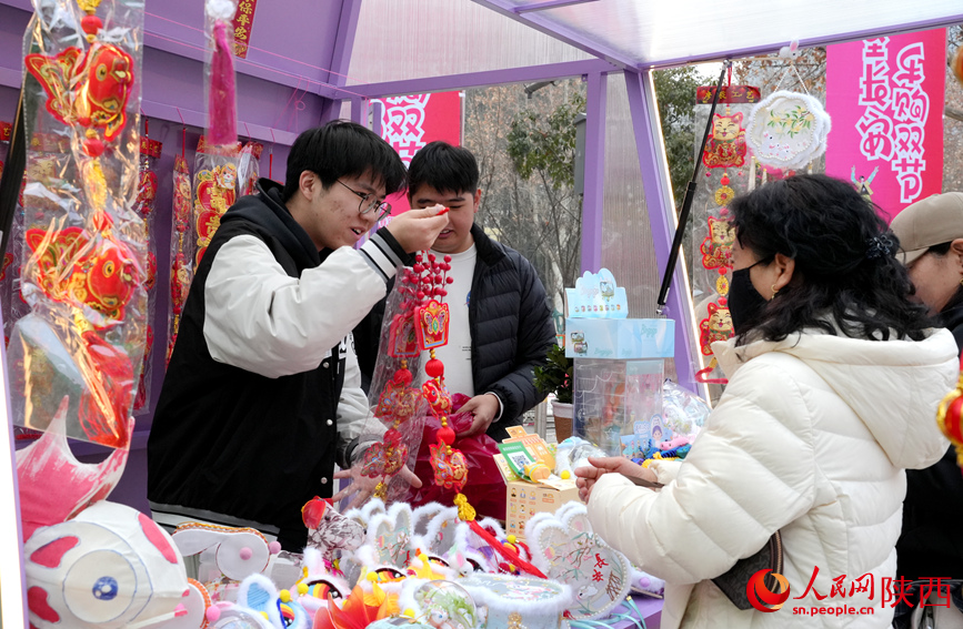 市民在攤位前采購春節(jié)飾品。人民網(wǎng)記者 賈凱璐攝