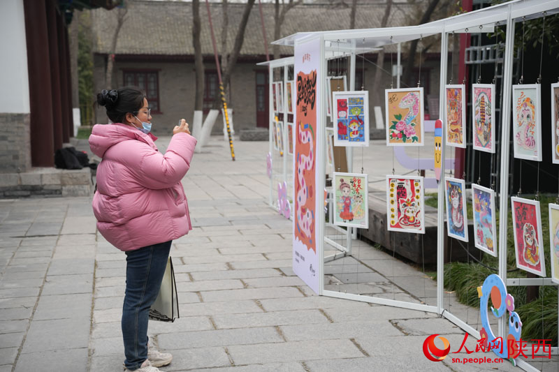 游客在觀看展出的蛇年主題繪畫作品。人民網(wǎng)記者 李志強(qiáng)攝