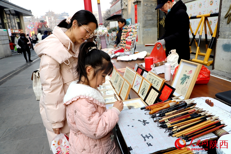 游客在書院門步行街體驗(yàn)書法。人民網(wǎng)記者孫挺 攝