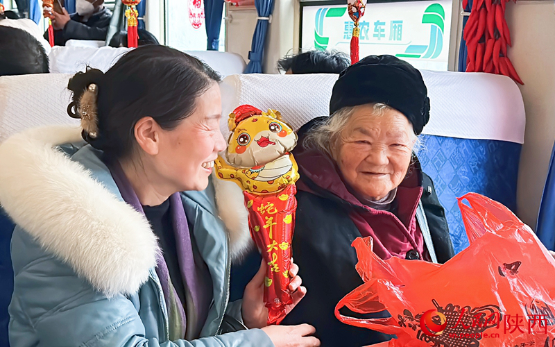 乘客們收到列車班組送的小禮物很開心。人民網(wǎng)記者 白鴿攝