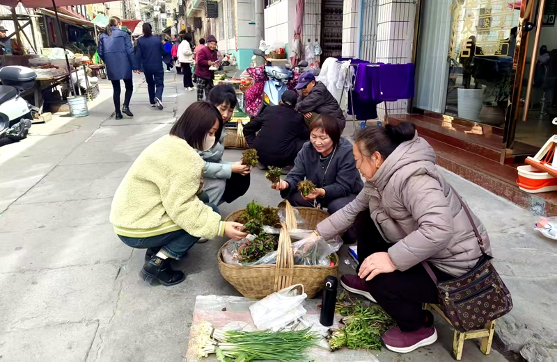 顧客正在攤位前挑選新鮮的野菜。王輝攝