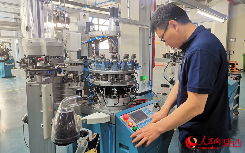 工人正在調(diào)試智能化襪業(yè)一體機(jī)。人民網(wǎng) 王麗攝