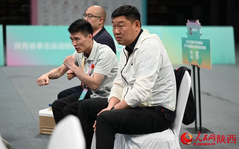 場邊，教練組的成員們緊緊盯著場上選手的表現(xiàn)。人民網(wǎng)記者 白鴿攝