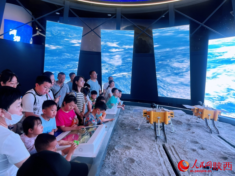 “逐夢空天”展區(qū)，市民游客在觀看探月科教視頻。人民網(wǎng)記者 魏鑫攝