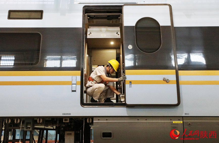 地勤機(jī)械師正在對(duì)動(dòng)車組進(jìn)行全面檢查。人民網(wǎng)記者 賈凱璐攝