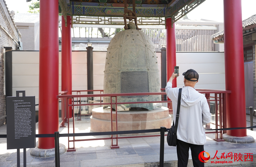 游客在國寶級文物“景云鐘”前拍照“打卡”。人民網記者 李志強攝