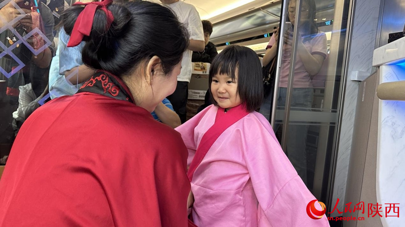 小旅客現(xiàn)場(chǎng)體驗(yàn)漢服。人民網(wǎng)記者 白鴿攝