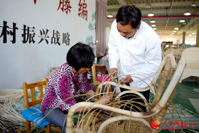 陳良順（右）正在教授工人藤編技藝。人民網(wǎng)記者 鄒星攝