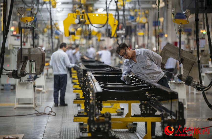 6月20日，在陜汽車架廠生產(chǎn)線上，工人們正在忙碌工作。人民網(wǎng)記者 翁奇羽攝