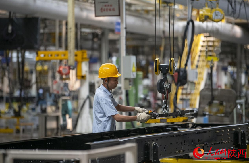 6月20日，在陜汽車架廠生產(chǎn)線上，工人們正在忙碌工作。人民網(wǎng)記者 翁奇羽攝