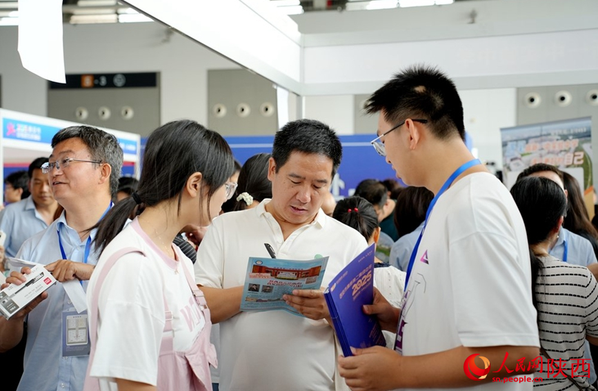 西安中招會(huì)現(xiàn)場(chǎng)，學(xué)校招生老師認(rèn)真詳細(xì)為家長考生答疑解惑。人民網(wǎng)記者 孫挺攝