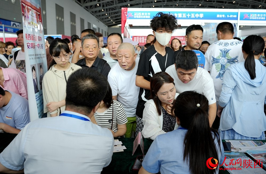 西安中招會現(xiàn)場，學校招生老師認真詳細為家長考生答疑解惑。人民網(wǎng)記者 孫挺攝