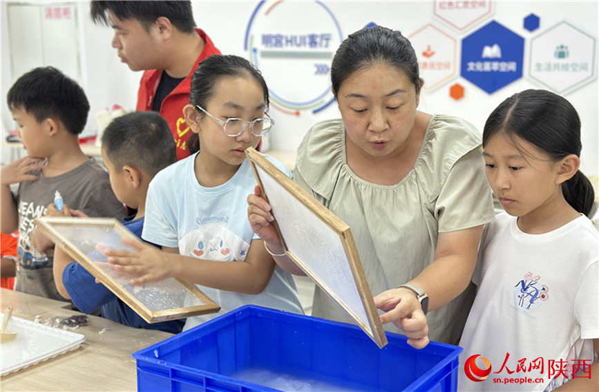 7月16日下午，西安市新城區(qū)明宮社區(qū)暑托班的“古法造紙”興趣課堂現(xiàn)場(chǎng)。人民網(wǎng)記者 李志強(qiáng)攝