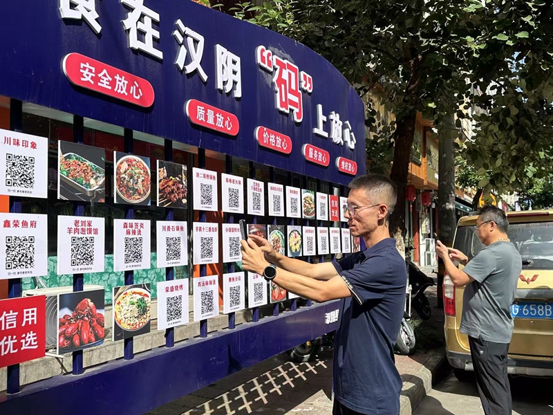 漢陰縣榮盛街頭，顧客食客只需掃碼即可觀看對(duì)應(yīng)餐飲店后廚實(shí)況視頻。漢陰縣融媒體中心供圖