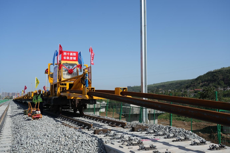 在西十高鐵施工現(xiàn)場，鋪軌機(jī)正在將首對500米長鋼軌平穩(wěn)地鋪設(shè)在無砟軌道板。籍振新攝