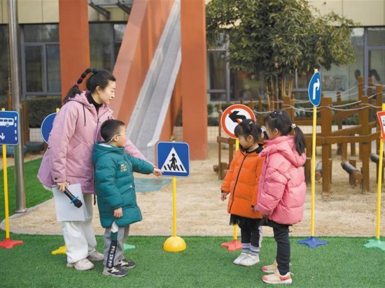 2月14日，西安市第二保育院大二班的小朋友康康（左二）和他的媽媽作為當日的晨會主持人，與其他小朋友一起學習交通安全知識。郭詩夢攝