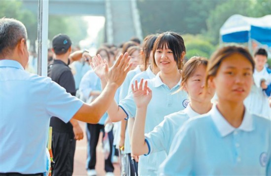 6月21日，渭南市瑞泉中學(xué)考點(diǎn)外，考生入場前與老師擊掌加油。2025年陜西省初中學(xué)業(yè)水平考試期間，渭南市各部門統(tǒng)籌配合，為考生提供交通出行、醫(yī)療衛(wèi)生等服務(wù)保障。 通訊員 崔正博攝