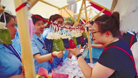 6月26日傍晚，中醫(yī)藥夜市吸引市民前來咨詢體驗。