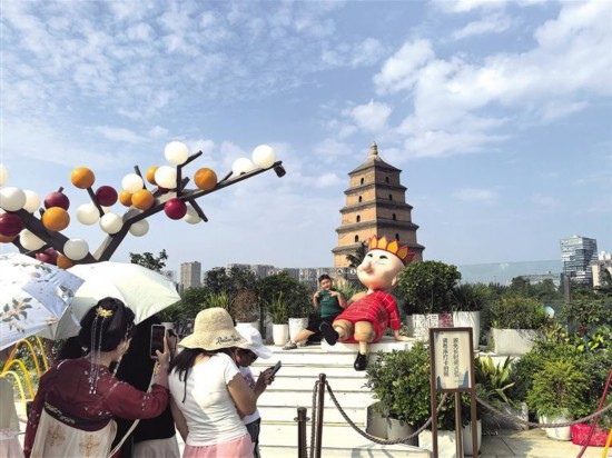 7月23日，游人在大悅城觀景平臺(tái)上以大雁塔為背景拍照打卡。