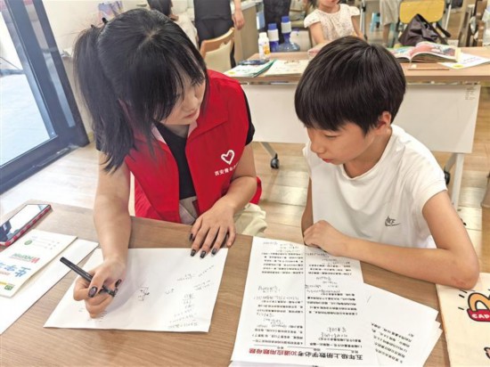 八月十五日，在西安市新城區(qū)尚樸社區(qū)老年服務(wù)中心，西安市小火柴志愿者服務(wù)中心志愿者在輔導(dǎo)孩子完成暑假作業(yè)。